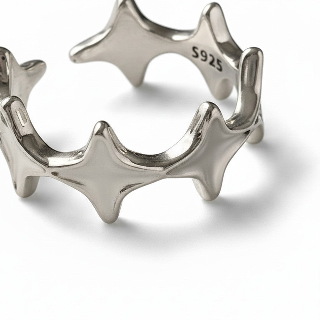 Maniac silver stainless steel open-end ring with irregular four eight-pointed stars design.
